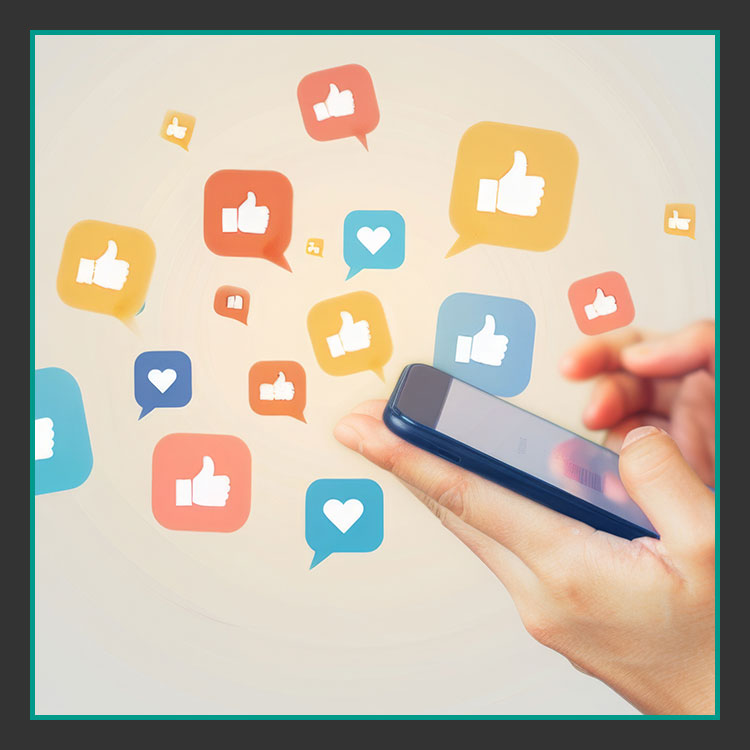 Eine Person hält ein Smartphone in den Händen. Verschiedene bunte Sprechblasen schweben umher und zeigen Like- und Herz-Symbole. Der Hintergrund ist ein sanfter Farbverlauf, der an die Interaktion in sozialen Medien erinnert.