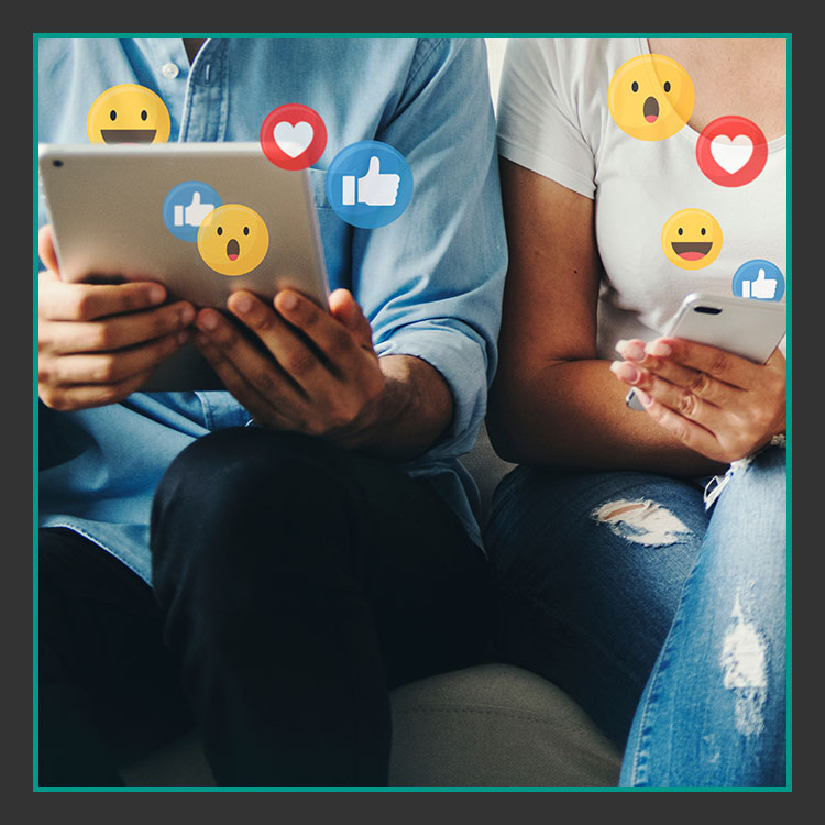 Social Media Inhalt content Zwei Personen sitzen zusammen und nutzen ein Tablet und ein Smartphone. Um sie herum schweben verschiedene Social-Media-Reaktionssymbole wie Daumen hoch, Herz und überraschtes Gesicht und suggerieren Online-Interaktion und Engagement.